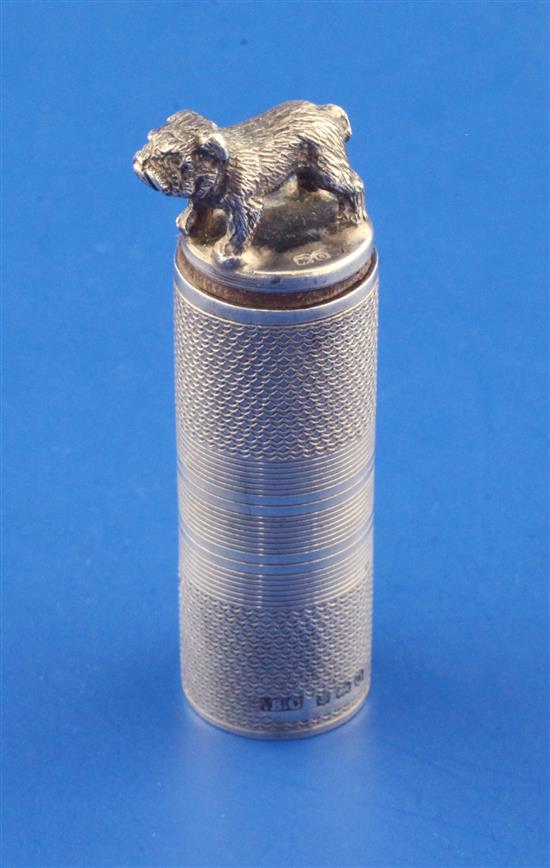 A George V engine turned silver cylindrical scent bottle with pug dog finial, 2.25in.